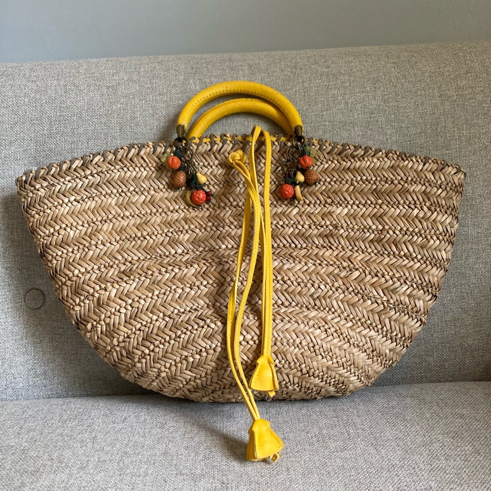 Bagamunda rattan beach bag with yellow handle and tropical fruit charms